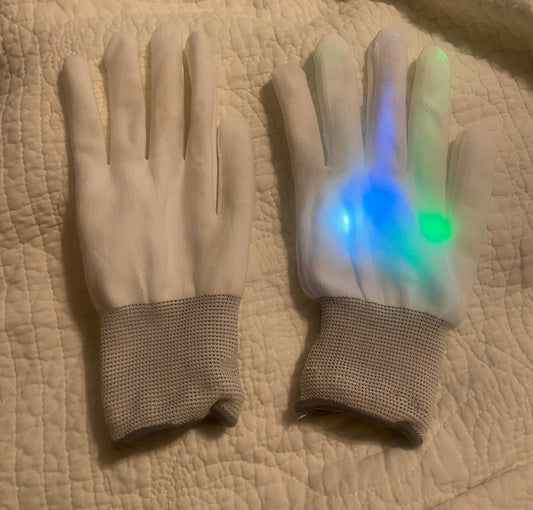 Pair of light up white gloves depress button to